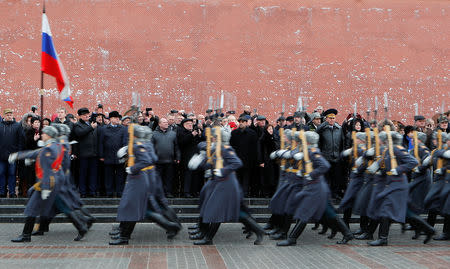 Participants, including veterans of the military campaign, watch honor guards marching past during a ceremony marking the 30th anniversary of the withdrawal of Soviet troops from Afghanistan in front of the Kremlin wall in central Moscow, Russia February 15, 2019. REUTERS/Maxim Shemetov