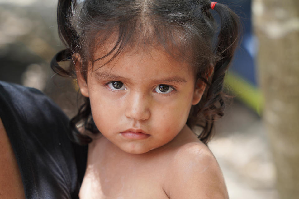 A grandmother holds her 2-year-old in Matamoros, Mexico, as her family waits for an appointment to present themselves at the Brownsville, Texas, port of entry. (Gabe Gutierrez / NBC News)