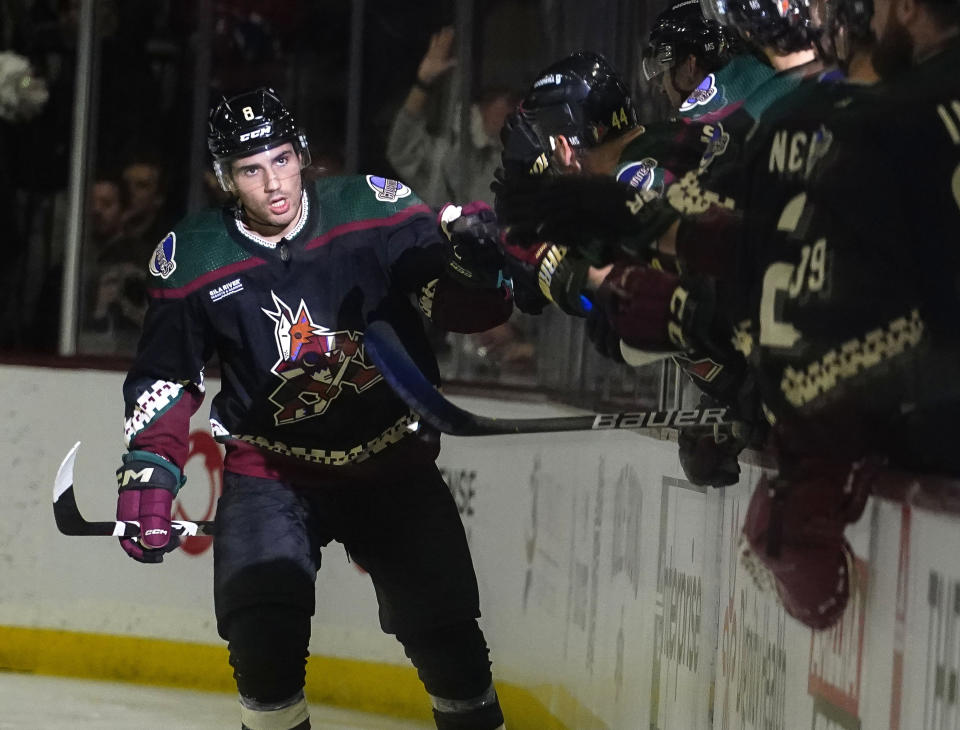 Arizona Coyotes' Nick Schmaltz (8) gets high-fives from teammates after scoring a goal against the Montreal Canadiens in the second period during an NHL hockey game, Monday, Dec. 19, 2022, in Tempe, Ariz. (AP Photo/Darryl Webb)