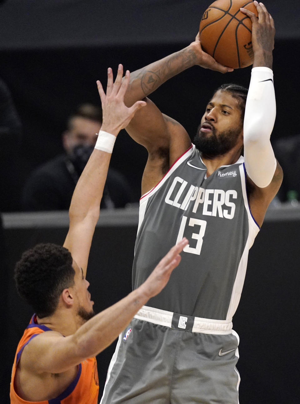 Los Angeles Clippers guard Paul George, right, shoots as Phoenix Suns guard Devin Booker defends during the second half in Game 4 of the NBA basketball Western Conference Finals Saturday, June 26, 2021, in Los Angeles. (AP Photo/Mark J. Terrill)