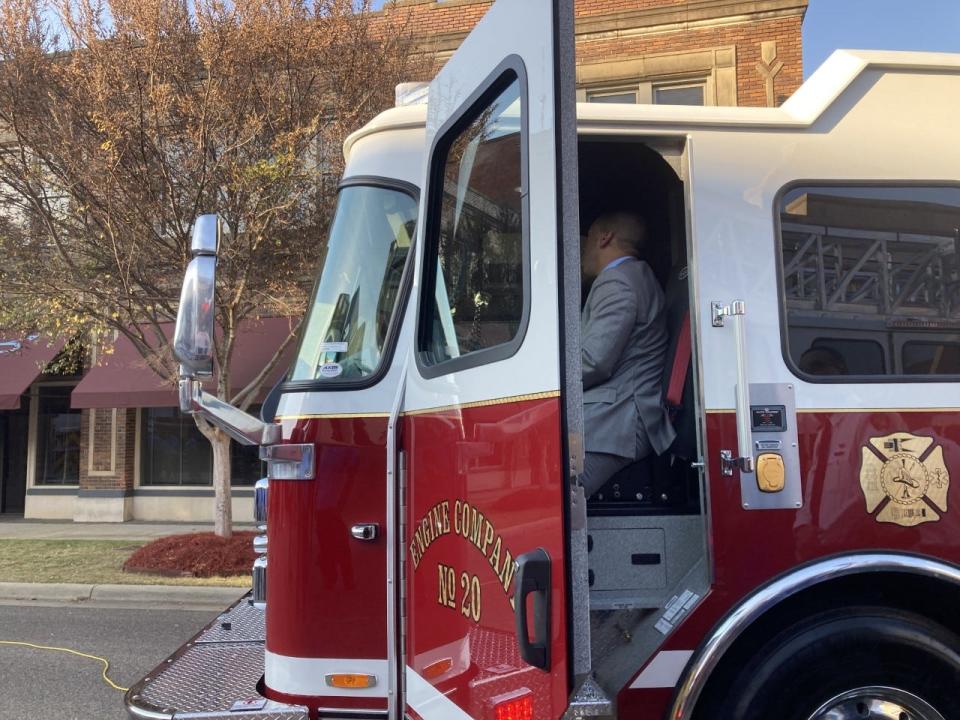 Mayor Steven Reed sits in one of the new fire trucks.