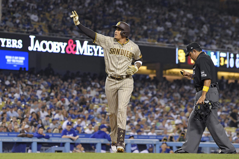 San Diego Padres' Manny Machado gestures as he scores after hitting a two-run home run during the third inning of a baseball game against the Los Angeles Dodgers Friday, Sept. 2, 2022, in Los Angeles. (AP Photo/Mark J. Terrill)