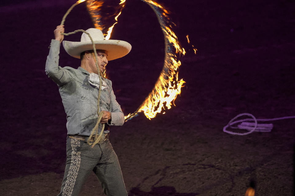 Luis Miguel Rivera hace trucos con un lazo el espectáculo "Jaripeo hasta los huesos tour 2024" de Pepe Aguilar en el Honda Center en Anaheim, California, el viernes 29 de marzo de 2024. El espectáculo rinde homenaje al Día de Muertos, una conocida celebración mexicana. (Foto AP/Damian Dovarganes)