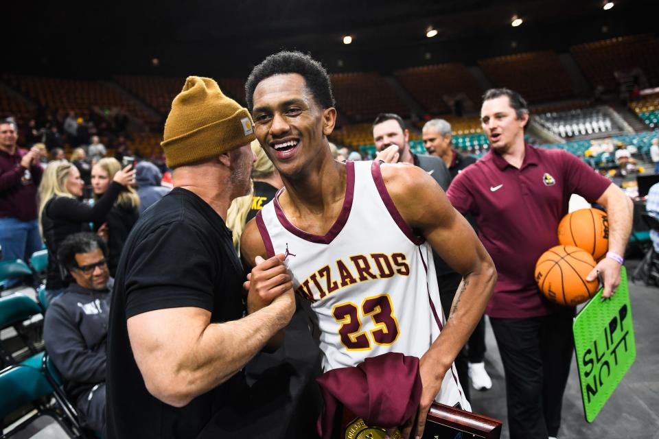Windsor boys basketball player David Hageman celebrates with a Wizards fan after winning a quarterfinals game against Longmont during the Colorado 5A state basketball tournament on March 2 at the Denver Coliseum.