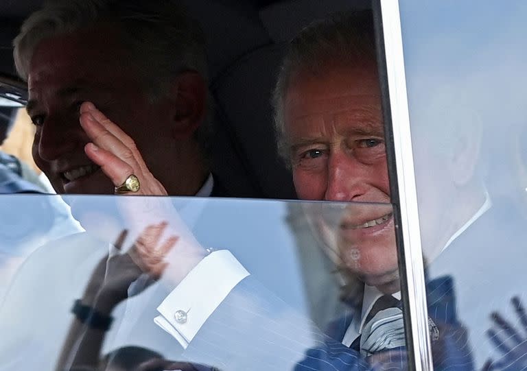 El rey Carlos III de Gran Bretaña saluda a los miembros del público que esperan cuando llega en automóvil al Palacio de Buckingham en Londres el 11 de septiembre de 2022.  (Photo by Alain JOCARD / AFP)