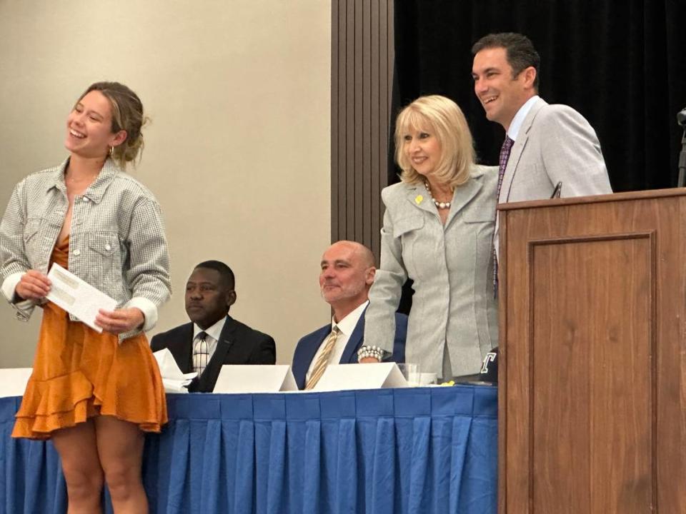 MAST Academy’s Sara Zampa (left) smiles after she was presented with a $1,000 scholarship from Herff Jones Miami. Zampa is congratulated by Miami-Dade County School Board Chair Mari Tere Rojas and Herff Jones Sales Representative Max Nieto (right).