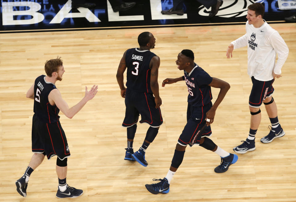 Connecticut players, left to right, Niels Giffey, Terrence Samuel, Amida Brimah, and Tyler Olander celebrate after after Connecticut defeated Iowa State 81-76 in a regional semifinal of the NCAA men's college basketball tournament Friday, March 28, 2014, in New York. (AP Photo/Julio Cortez)