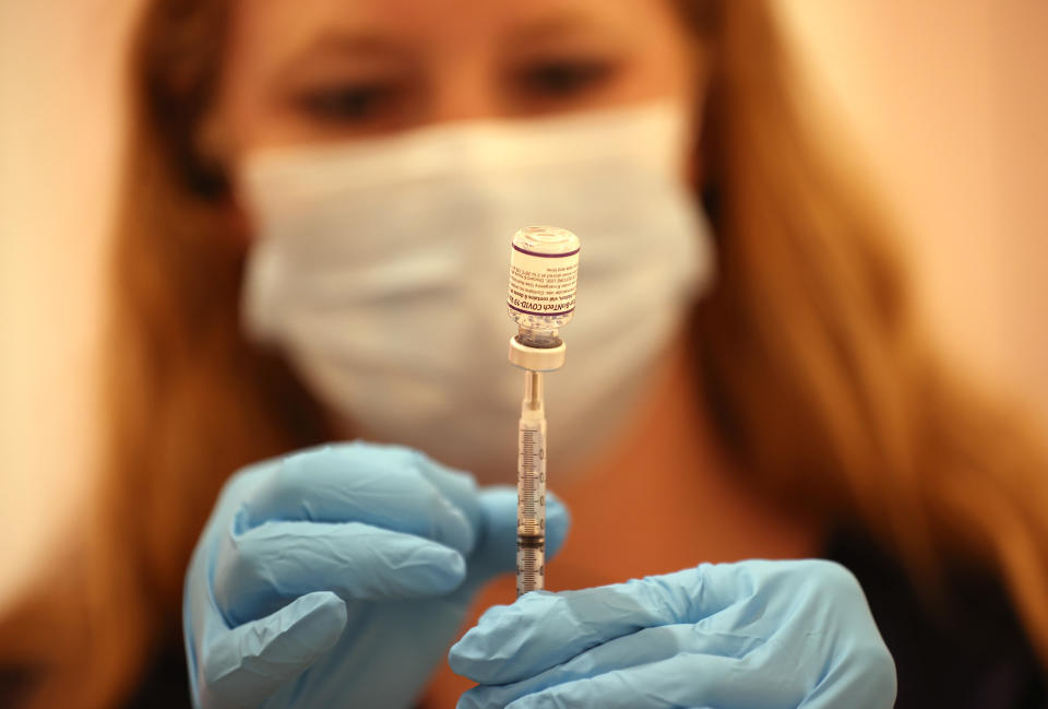 Safeway pharmacist Ashley McGee fills a syringe with the Pfizer COVID-19 booster vaccination at a vaccination clinic in October in San Rafael, Calif.