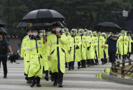 South Korean police officers wearing face masks walk in Seoul, South Korea, Saturday, Aug. 15, 2020. South Korea on Saturday announced stronger social distancing restrictions for its greater capital area where a surge in COVID-19 cases has threatened to erase the hard-won gains against the virus. (AP Photo/Lee Jin-man)