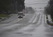 A few cars drive along an almost deserted Market St. in Wilmington, N.C., Thursday, Sept. 13, 2018. Florence's outer bands of wind and rain began lashing North Carolina on Thursday. (Matt Born/The Star-News via AP)