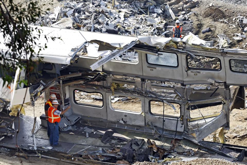 FILE - Investigators photograph the mangled inside of a Metrolink commuter train in Chatsworth, Calif., Sept. 14, 2008. Passenger railroads nationwide will now be required to install video recorders inside their locomotives, but the head of the National Transportation Safety Board said the new rule is flawed because it excludes freight trains like the one that derailed and caught fire in eastern Ohio, in February 2023. The NTSB made its recommendation to add cameras in locomotives in 2010 after it investigated the deadly 2008 collision between a Metrolink commuter train and a Union Pacific freight train. (AP Photo/Richard Vogel, File)