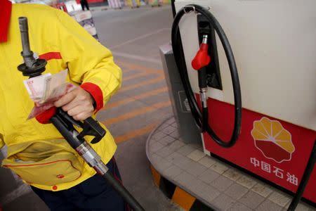 A gas station attendant pumps fuel into a customer's car at PetroChina's petrol station in Beijing, China, March 21, 2016. REUTERS/Kim Kyung-Hoon/File Photo