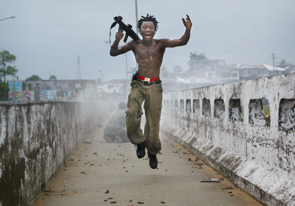 Joseph Duo, a Liberian militia commander loyal to the government exults after firing a rocket-propelled grenade at rebel forces, July 20, 2003, in Monrovia, Liberia. (Photo: Chris Hondros/Getty Images)