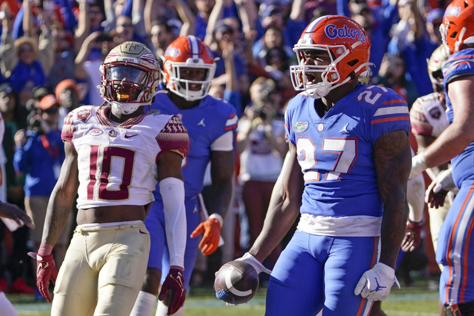 Florida running back Dameon Pierce (27) celebrates a 3-yard touchdown run as Florida State defensive back Jammie Robinson (10) looks on during the second half of an NCAA college football game, Saturday, Nov. 27, 2021, in Gainesville, Fla. (AP Photo/John Raoux)