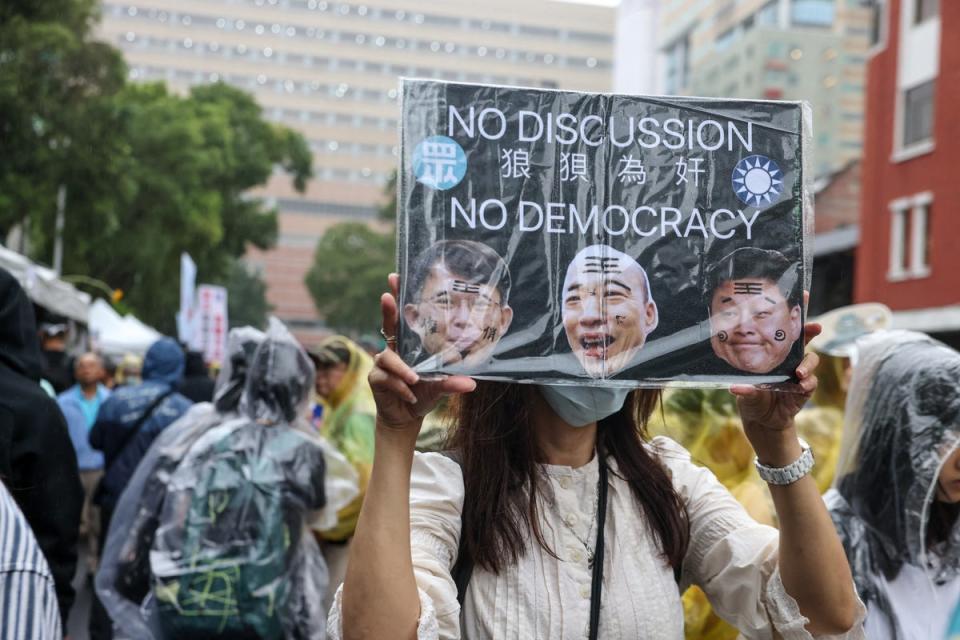 A protestor holds a sign reading 