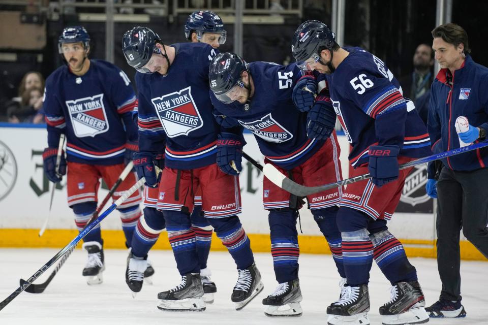 New York Rangers' teammates help Ryan Lindgren (55) off the ice after he was injured during the second period of an NHL hockey game against the New York Islanders, Sunday, March 17, 2024, in New York.