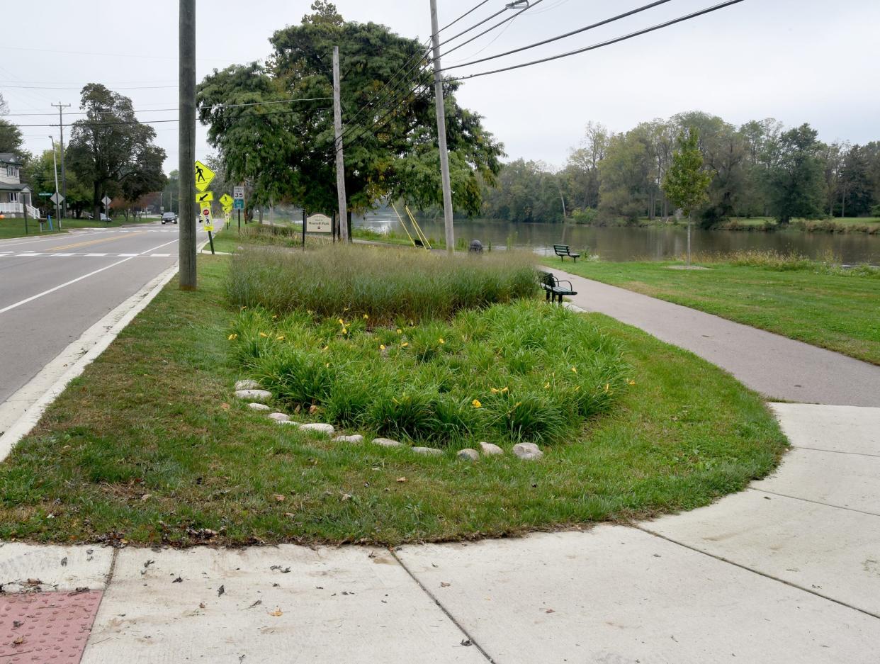 A bicycle route loops around a garden marking the Mark Worrell Trail off W. Elm Ave. (left) along the River Raisin in the City of Monroe.