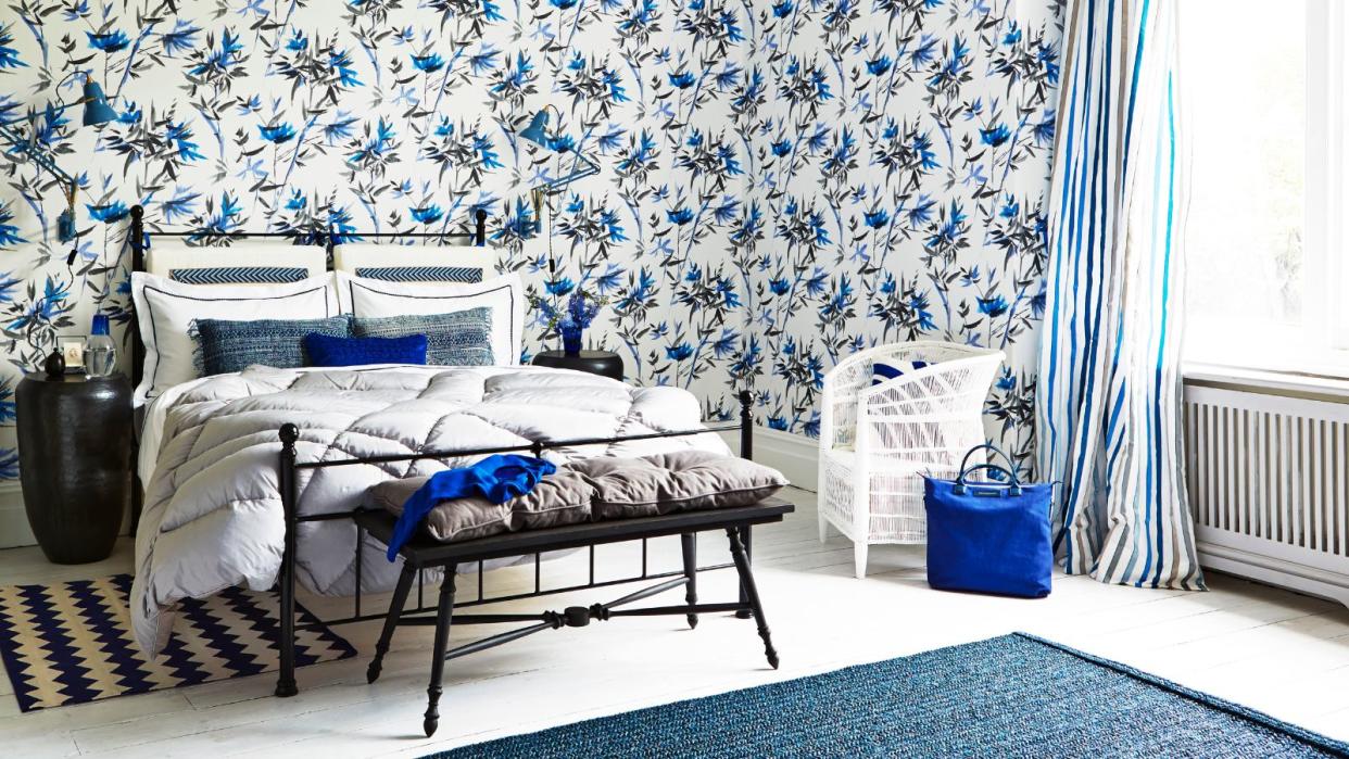  A blue bedroom with blue wallpaper and accents 