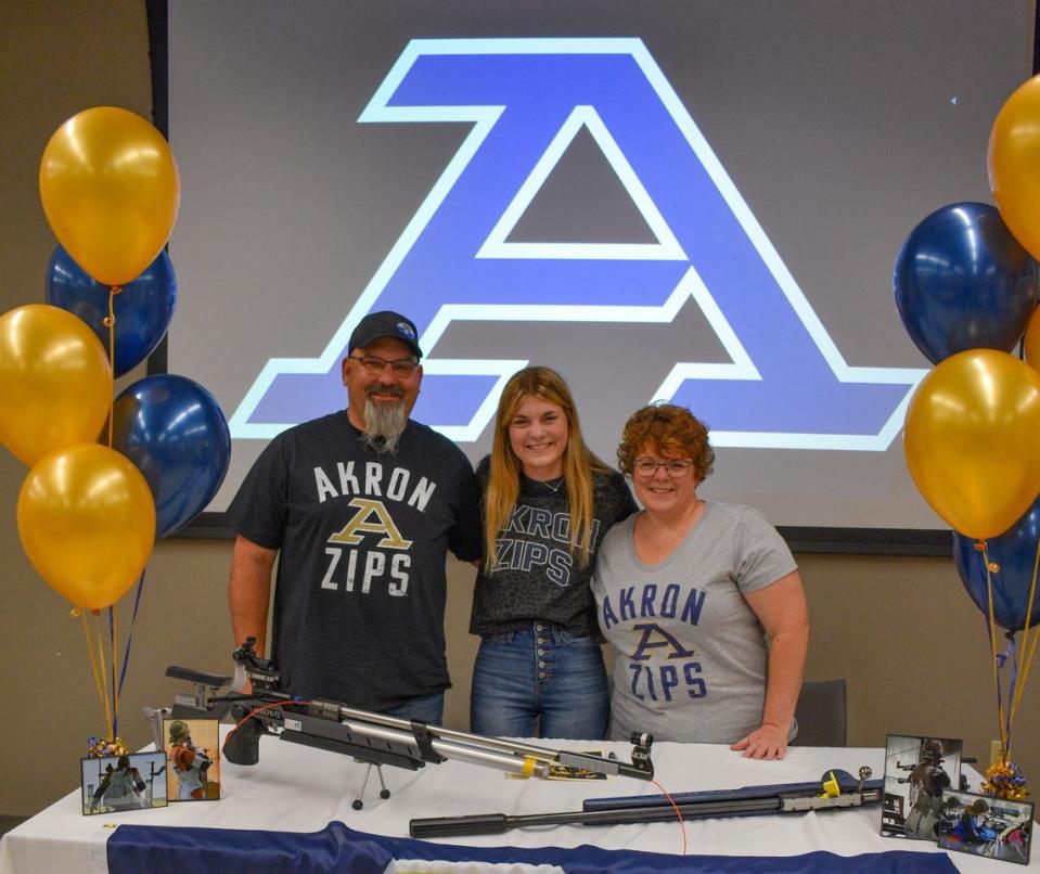 Patrick and Sandy Heschel supported their daughter’s passion for marksmanship since she was a young girl, going so far as to transform their basement into a gun range. Here, from left, are Patrick, Diane and Sandy celebrating Diane’s acceptance to the University of Akron Rifle Team.