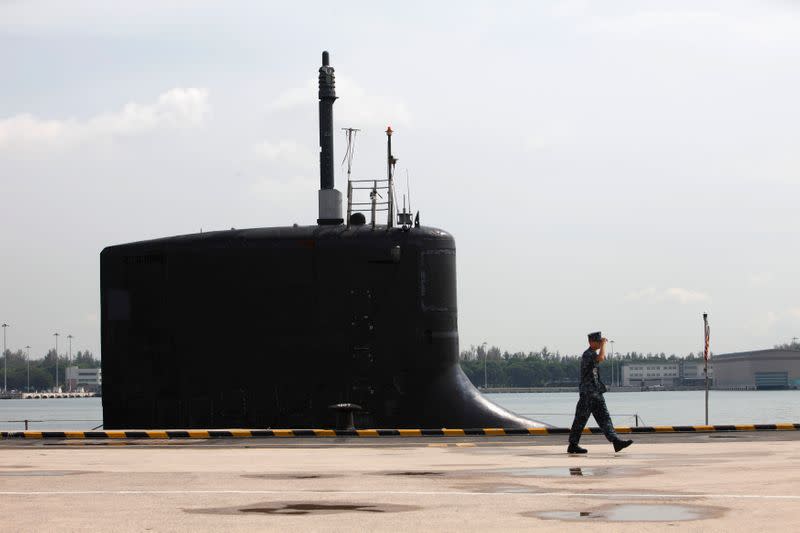 U.S. Navy personel walks past USS North Carolina submarine docked at Changi Naval Base in Singapore