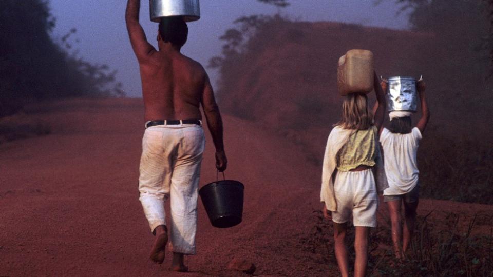 Una familia camina con recipientes de agua durante una sequía en el estado de Pará en Brasil