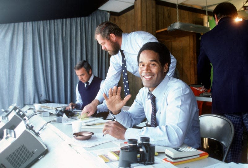 CIRCA 1980: NBC Football Analyst O.J. Simpson in the both smiling for the camera before the start of an NFL football game circa 1980. - Image: Focus on Sport (Getty Images)