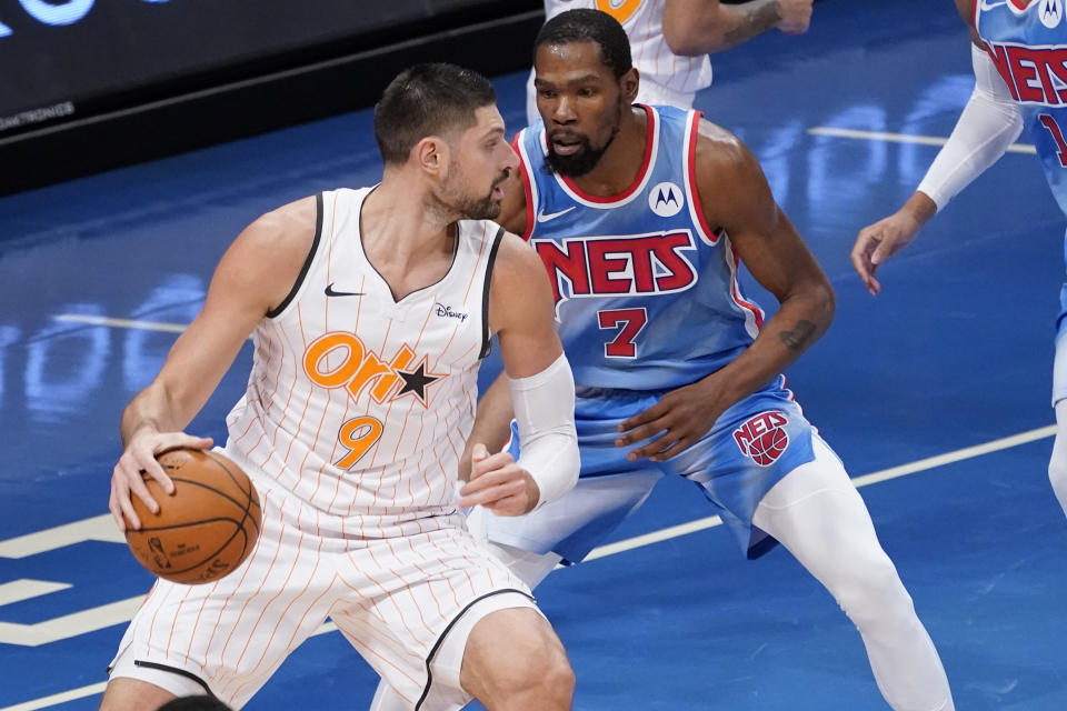 Orlando Magic center Nikola Vucevic (9) drives against Brooklyn Nets forward Kevin Durant (7) during the first half of an NBA basketball game, Saturday, Jan. 16, 2021, in New York. (AP Photo/Mary Altaffer)