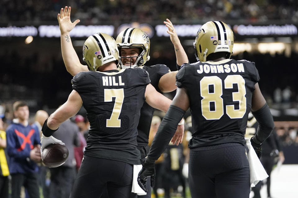 New Orleans Saints' Taysom Hill (7) celebrates his touchdown catch with quarterback Derek Carr, center, and tight end Juwan Johnson (83) during the first half of an NFL football game against the Chicago Bears in New Orleans, Sunday, Nov. 5, 2023. (AP Photo/Gerald Herbert)