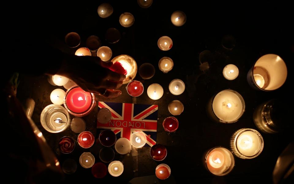 Members of the public light candles during the vigil in Trafalgar Square - Credit: PA/Yui Mok