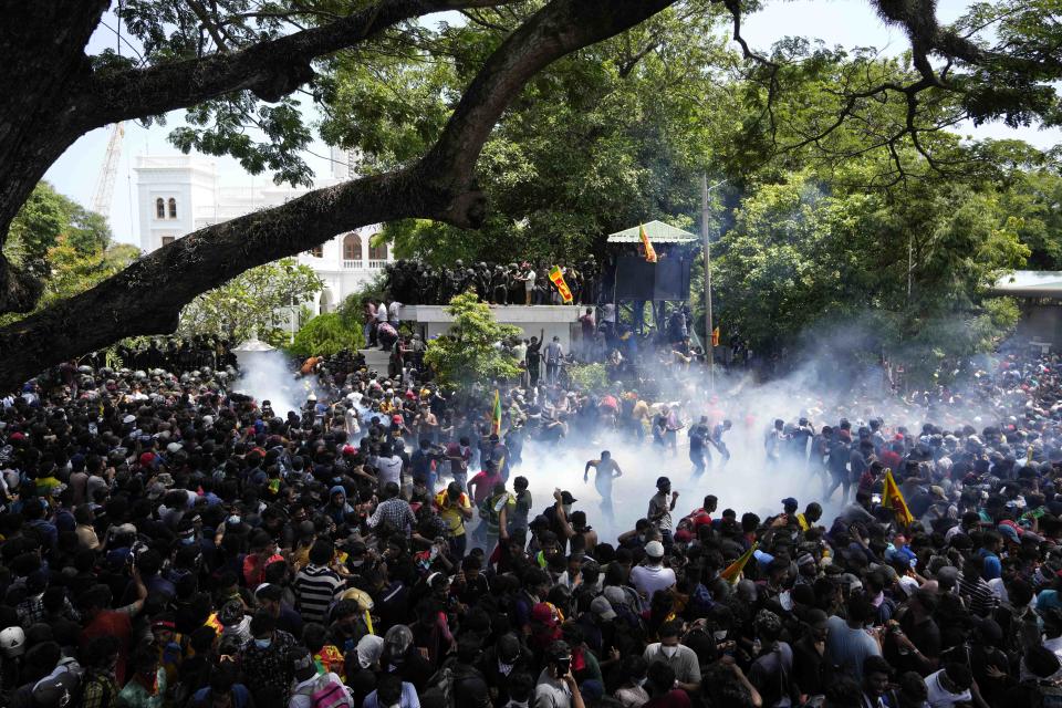 Police use tear gas as protesters storm the compound of prime minister Ranil Wickremesinghe 's office, demanding he resign after president Gotabaya Rajapaksa fled the country amid economic crisis in Colombo, Sri Lanka, Wednesday, July 13, 2022. The speaker of the Parliament said Rajapaksa appointed his prime minister as acting president in his absence. (AP Photo/Eranga Jayawardena)