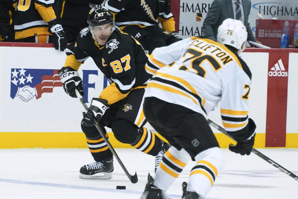 Pittsburgh Penguins' Sidney Crosby (87) brings the puck up ice past Boston Bruins' Connor Clifton (75) during the second period of an NHL hockey game Tuesday, Nov. 1, 2022, in Pittsburgh. (AP Photo/Keith Srakocic)