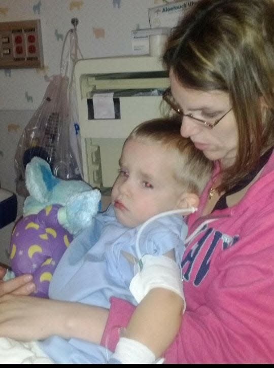 Roman is shown with his mom, Jamie Redd, after his first surgery at age 4.