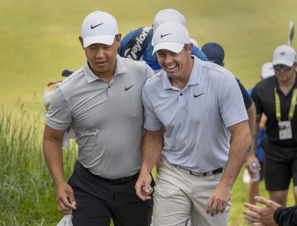 Rory McIlroy, right, of Northern Ireland and Tom Kim, of South Korea, share a laugh as they walk up a steep incline from the third green during the third round of Canadian Open golf tournament in Hamilton, Ontario, Saturday, June 1, 2024. (Frank Gunn/The Canadian Press via AP)