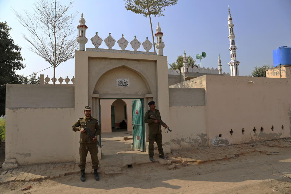 Police officers stand guard at a mosque, where an enraged mob stoned to death Mushtaq Ahmed, 41, for allegedly desecrating the Quran, in Tulamba, a remote village in the district of Khanewal in eastern Pakistan, Sunday, Feb. 13, 2022. Mob attacks on people accused of blasphemy are common in this conservative Islamic nation where blasphemy is punishable by death. (AP Photo/Asim Tanveer)