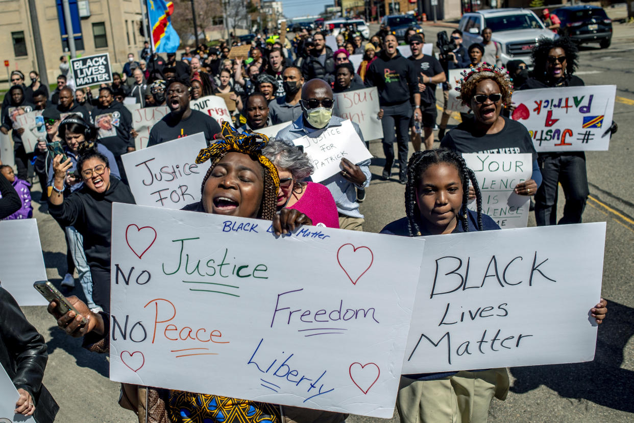 Rose Ajak of Lansing, Mich., center left, shouts out "No Justice, No Peace," while marching alongside her 10-year-old daughter Shanice with people wearing all black in support of the Lyoya family on Thursday, April 21, 2022 at the Capitol in Lansing, Mich. to demand justice in the police shooting that took the life of Congolese immigrant Patrick Lyoya. (Jake May/The Flint Journal via AP)