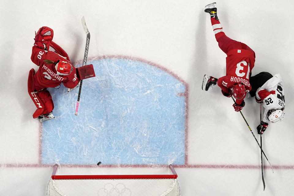 Switzerland's Alina Muller, right, shoots to score past Russian Olympic Committee goalkeeper Valeria Merkusheva, left, and Russian Olympic Committee's Nina Pirogova, center, during a women's quarterfinal hockey game between Russian Olympic Committee and Switzerland at the 2022 Winter Olympics, Saturday, Feb. 12, 2022, in Beijing. (AP Photo/Petr David Josek)