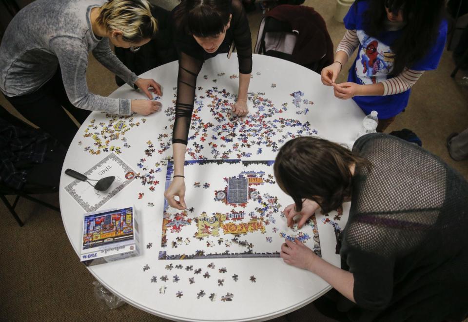 Clockwise, Dana Tzvetkov, Sarah Akemon, Nika Zulkowski and Sarah Travis work on a puzzle at the Monroe County History Center in January 2019. More puzzles will be pieced together at this year's Puzzlefest.