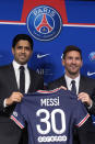 Lionel Messi, right, poses with his jersey with PSG president Nasser Al-Al-Khelaifi during a press conference Wednesday, Aug. 11, 2021 at the Parc des Princes stadium in Paris. Lionel Messi said he's been enjoying his time in Paris "since the first minute" after he signed his Paris Saint-Germain contract on Tuesday night. The 34-year-old Argentina star signed a two-year deal with the option for a third season after leaving Barcelona. (AP Photo/Francois Mori)