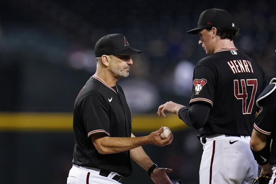 Arizona Diamondbacks manager Torey Lovullo, left, takes the ball from starting pitcher Tommy Henry (47) during the fifth inning of the team's baseball game against the Philadelphia Phillies on Wednesday, Aug. 31, 2022, in Phoenix. (AP Photo/Ross D. Franklin)