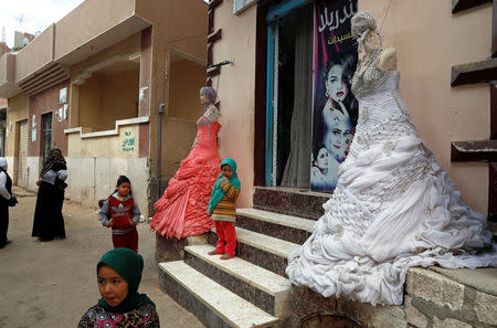 Egyptian girls play outside a shop for brides in the province of Fayoum, southwest of Cairo, Egypt February 19, 2019. Picture taken February 19, 2019. REUTERS/Hayam Adel
