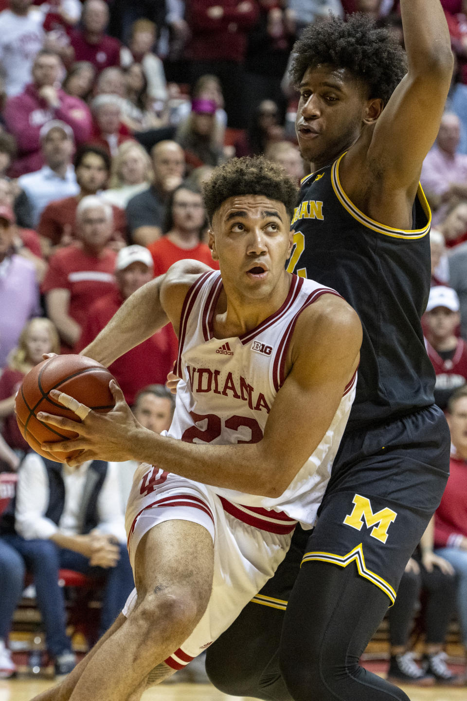 Indiana forward Trayce Jackson-Davis drives along the baseline while being defended by Michigan forward Tarris Reed Jr. (32) during an overtime period of an NCAA college basketball game, Sunday, March 5, 2023, in Bloomington, Ind. (AP Photo/Doug McSchooler)