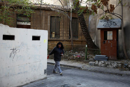 A woman walks next to an abandoned military outpost near the UN-controlled buffer zone in Nicosia, Cyprus November 11, 2016. REUTERS/Yiannis Kourtoglou