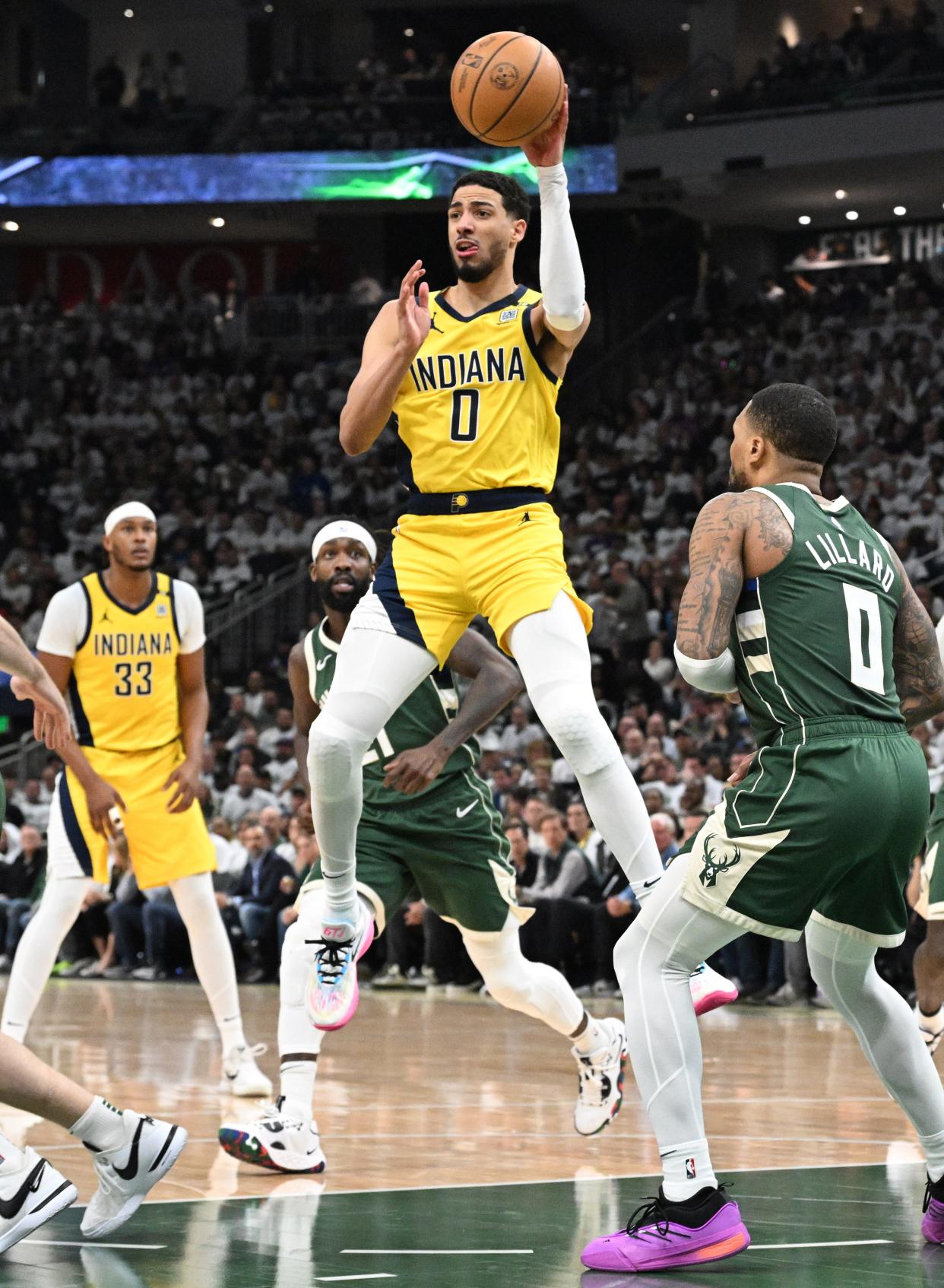 Pacers guard Tyrese Haliburton  makes a pass against Bucks guard Damian Lillard on Tuesday night. Haliburton finished with 12 assists.