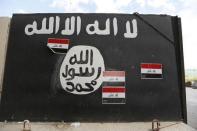 A wall painted with the black flag commonly used by Islamic State militants, near former Iraqi president Saddam Hussein's palace in Tikrit April 1, 2015. REUTERS/Thaier Al-Sudani