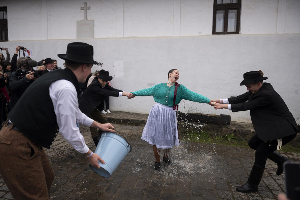 Hungarian men wearing folk costumes pour water onto women during a traditional a Easter Monday celebration in Holloko, Hungary, Monday, April 10, 2023. (AP Photo/Denes Erdos)