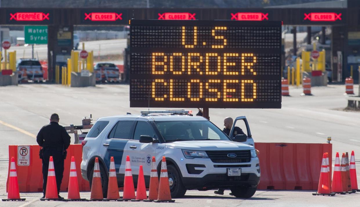 <span class="caption">U.S. Customs officers stand beside a sign at the US/Canada border in Lansdowne, Ontario, on March 22, 2020.</span> <span class="attribution"><a class="link " href="https://www.gettyimages.com/detail/news-photo/customs-officers-stand-beside-a-sign-saying-that-the-us-news-photo/1207963430?adppopup=true" rel="nofollow noopener" target="_blank" data-ylk="slk:Lars Hagberg / AFP via Getty Images;elm:context_link;itc:0;sec:content-canvas">Lars Hagberg / AFP via Getty Images</a></span>