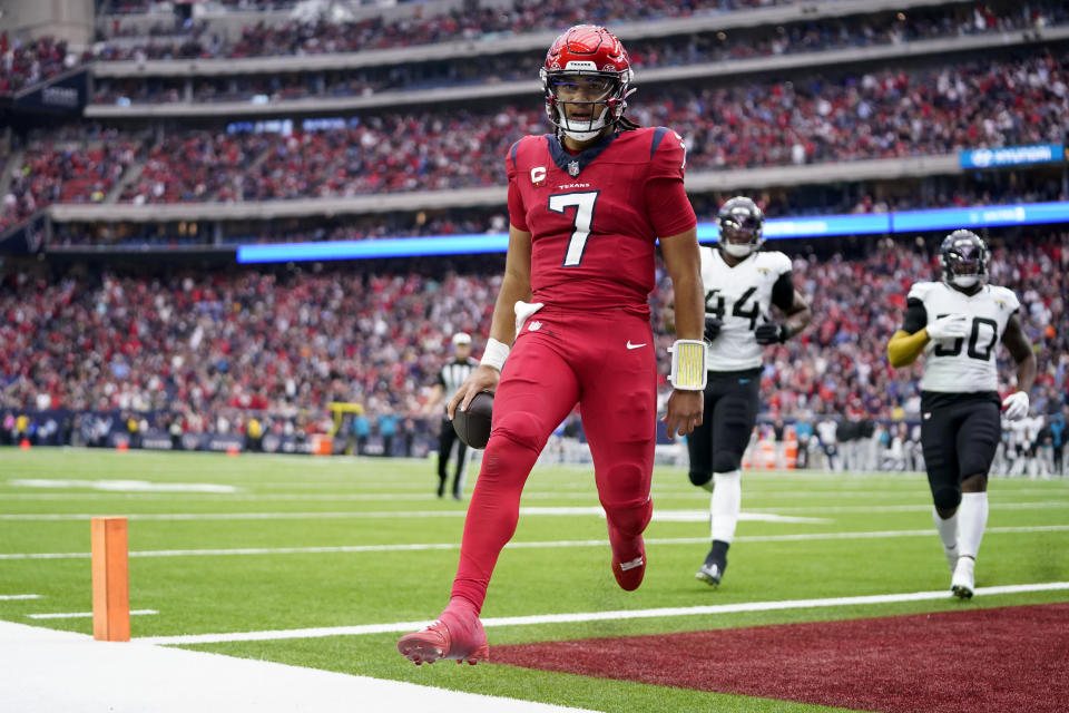 Houston Texans quarterback C.J. Stroud (7) scores a touchdown on a running play after evadnig Jacksonville Jaguars' Travon Walker (44) and Shaquille Quarterman (50) in the second half of an NFL football game in Houston, Sunday, Nov. 26, 2023. (AP Photo/Eric Christian Smith)