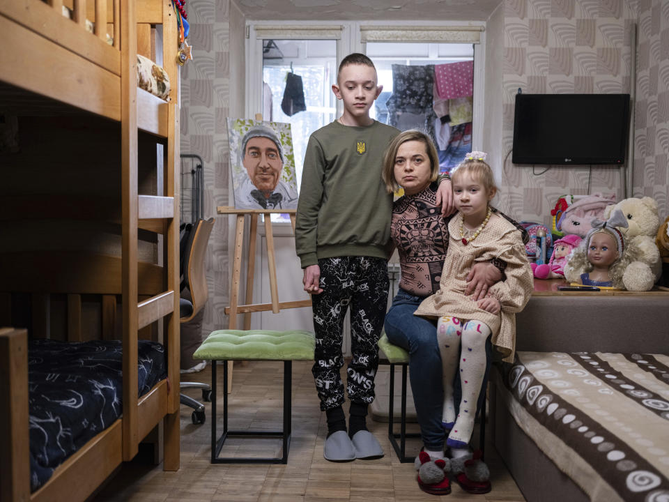 Natalia Sheleshei, 39, with her children Yehor, 12, and Anastasia, 5, wait for the return of Serhii at their apartment in Kyiv, Ukraine on Feb. 12, 2024. Serhii Sheleshei, 49, a Ukrainian serviceman went missing with three of his comrades during fighting at the frontline near Zaitseve, Donetsk region, on Oct. 12, 2022. "For a year and five months, I've lived with the uncertainty of whether my husband is alive or not," Natalia, who juggles two jobs, says. "He adored the children. Whenever he could, he would call, saying 'I love you' and 'I worry about you'," Natalia recounts about the time when Serhii was at the frontline. (AP Photo/Evgeniy Maloletka)