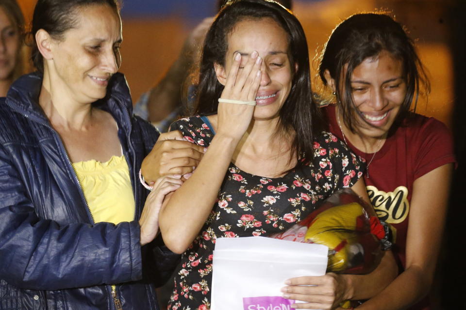 Karen Palacios, center, is helped by family members after she was released from prison at Los Teques on the outskirts of Caracas, Venezuela, Tuesday, July 16, 2019. Palacios who plays the clarinet and was cut from the National Philharmonic for criticizing the government, was detained for 6 weeks. (AP Photo/Ariana Cubillos)