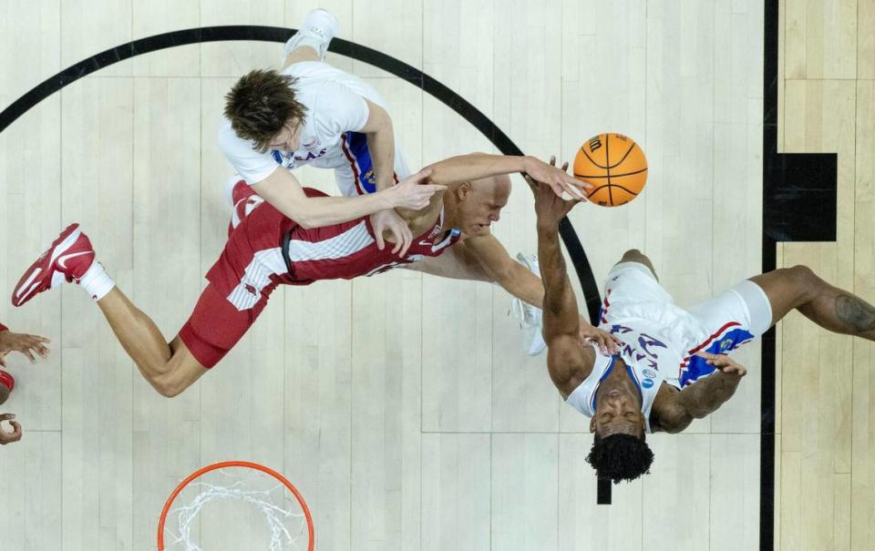 Kansas forwards K.J. Adams Jr. (24) and Zach Clemence (21) contest a shot by Arkansas guard Jordan Walsh (13) during a second-round college basketball game in the NCAA Tournament Saturday, March 18, 2023, in Des Moines, Iowa.